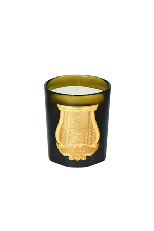An olive green murano class candle vessel with a gold crest logo with white wax on a white background. 