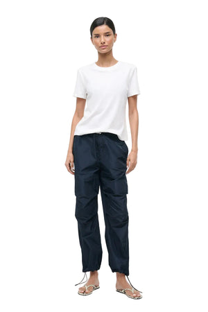 Person wearing a white t-shirt and black pants on a white background