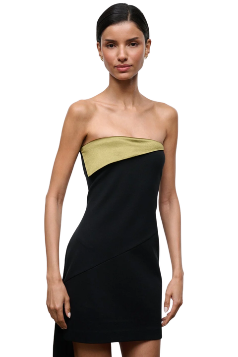 A model wearing a strapless black bodycon dress with a diagonal olive green accent band across the bust, photographed against a plain white background.