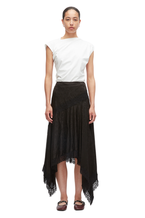 Model wearing a white shirt and black floral jacquard handkerchief skirt. 
