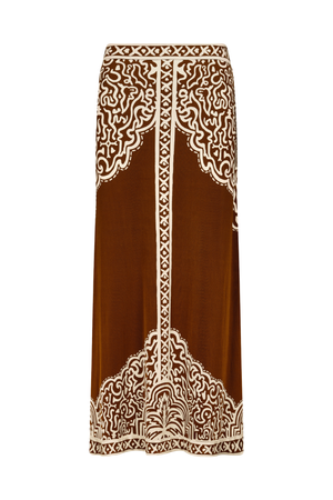 A brown midi skirt with intricate cream-colored bohemian-style embroidery, featuring ornate patterns at the waistband and hem, shown against a plain white background.