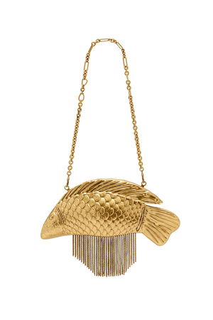 A gold fish-shaped shoulder bag with a textured scale pattern and dangling fringe, suspended from a delicate gold chain strap against a plain white background.