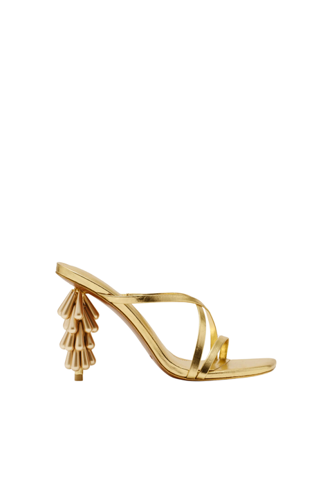 A single metallic gold strappy sandal with a sculptural, tiered geometric heel, shown from a side profile on a solid white background.