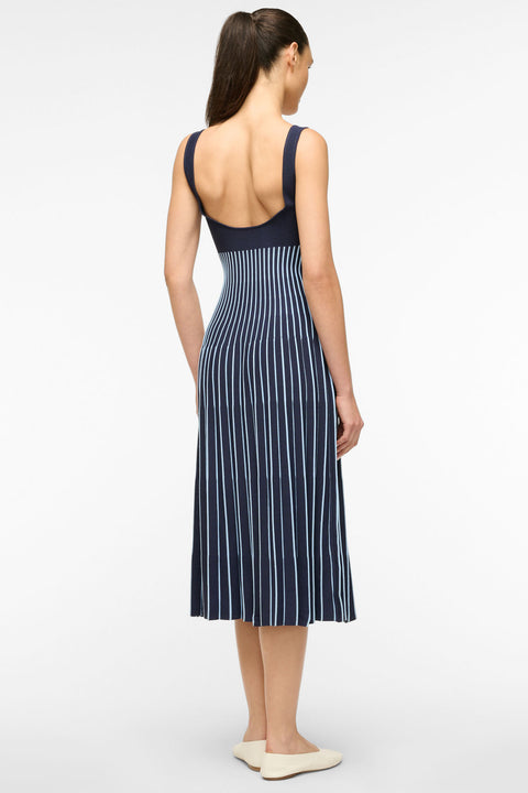 Back view of a woman wearing a navy and light blue striped knit midi dress. 