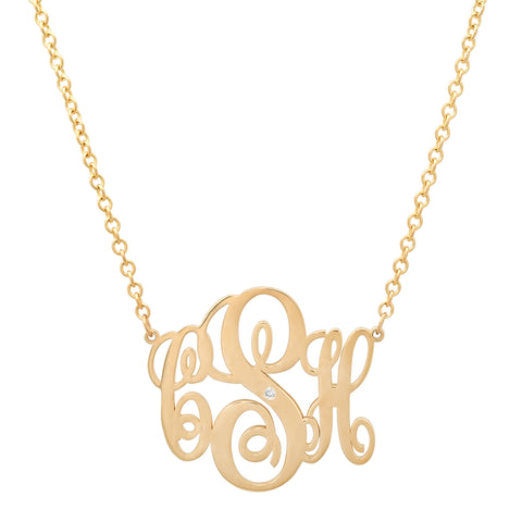 A yellow gold necklace on a rolo chain with a cutout cursive monogram of "CSH" with a small diamond set in the middle of the S.