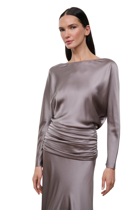 A woman modeling a long-sleeve satin dress in a muted taupe-gray color against a plain white background.