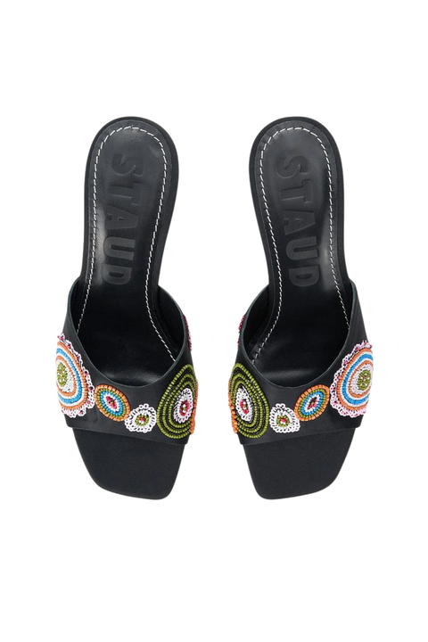 A pair of black slide sandals with colorful beaded floral details on the straps, shown from a top-down view on a white background. The brand name 'STAUD' is embossed on the insoles.