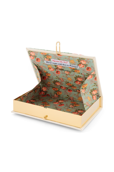 An open book clutch with a floral patterned interior and a cream-colored cover, shown on a white background.