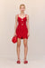 Woman wearing a red crochet mini dress that features a floral design and keyhole cutouts at the bust, paired with red accessories. 