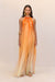 Woman wearing a bright orange ombre maxi dress that features a high neck with cutouts with gold beads and long, cascading ribbons for a flowing skirt effect. 