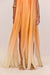 Close up of the skirt of an orange ombre maxi dress, featuring the cascading ribbons of silk that form the skirt. 