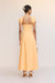 back view of a woman wearing a bright orange maxi dress that features cap sleeves and an open back detail. 