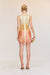 Back view of a woman wearing a yellow-orange ombre mini dress that features draped, beaded fringe across the body and a back zipper. 