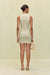 Back view of a woman wearing a khaki high-neck mini dress that features a utility design, front zipper, and sleek side pockets, paired with black sandals.  
