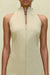 Close up of a woman wearing a khaki high-neck mini dress that features a utility design, front zipper, and sleek side pockets.  