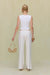 Back view of a white knit tank top with ribbing details, paired with white pants. 