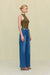 Side angle of a woman wearing an olive green sleeveless bodysuit that features a mock neck, paired with blue wide leg jeans. 