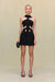 Woman wearing a black mini dress that features a high neck with cutouts in the midriff. 