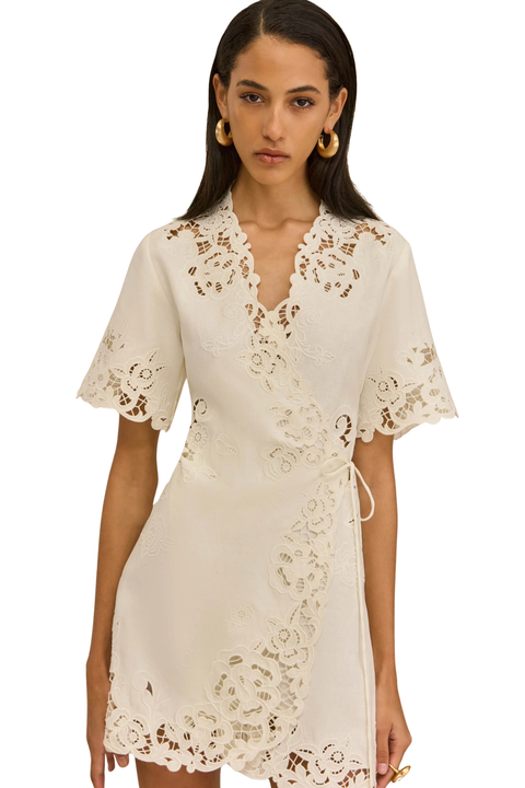 Woman wearing a white linen embroidered dress 