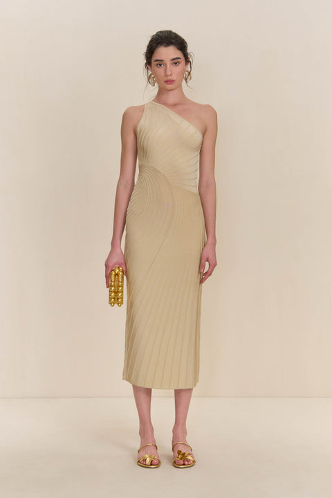 Woman wearing a cream knit midi dress that features a one-shoulder neckline and patterned ribbing. 
