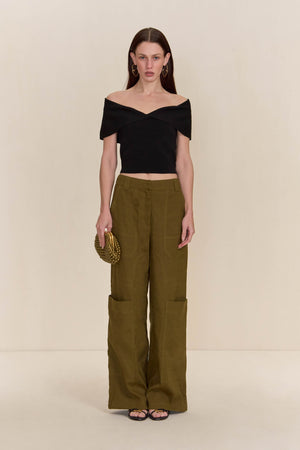 Woman wearing olive green cargo pants paired with a black off-the-shoulder top.