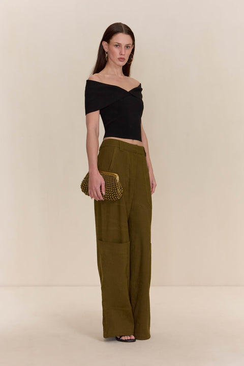 Side angle of a woman wearing olive green cargo pants paired with a black, off-the-shoulder top.