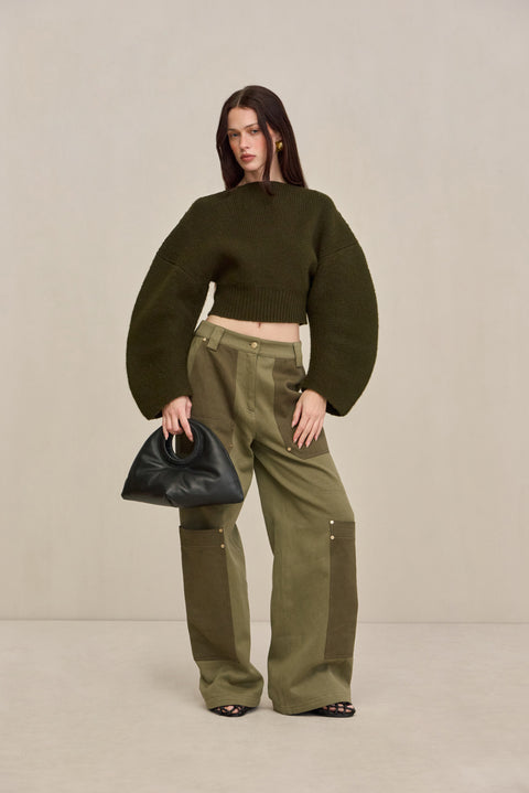 Woman wearing green two-tone cargo pants with a green structured top. 