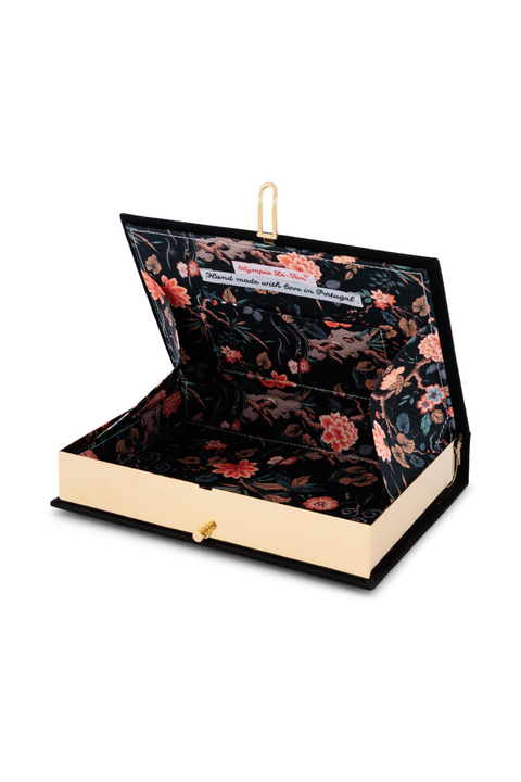 A book clutch with a black floral velvet interior and a black exterior, shown open on a white background.