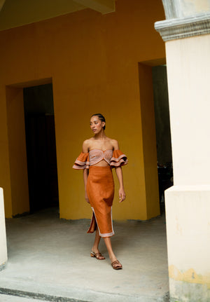 Model walking in the orange asere cropped top.