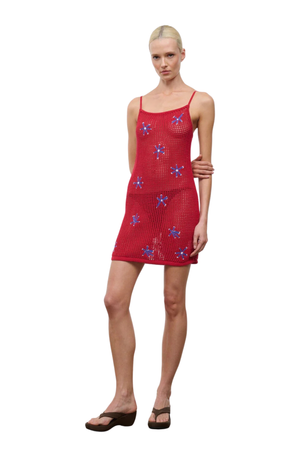 Woman wearing a red dress with floral patterns on a white background