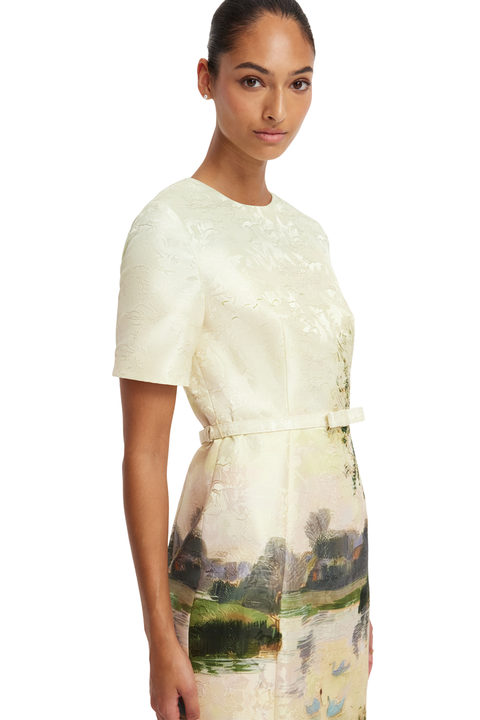 Woman wearing a dress with a scenic print on a white background