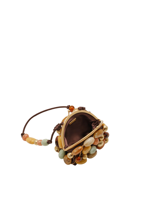 A small handbag with a brown leather strap and base, decorated with a cluster of smooth, polished stones in earthy tones of brown, beige, and green, set against a plain white background.