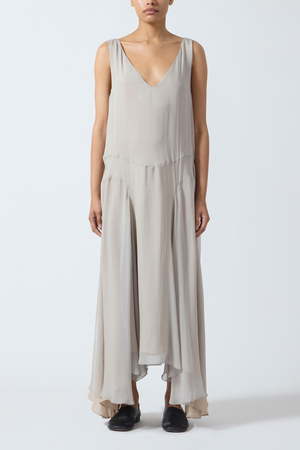 Woman wearing a grey beige sleeveless  maxi dress on a white background