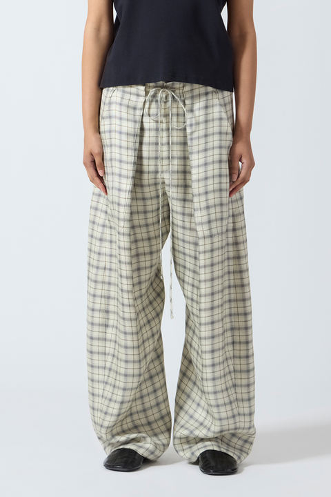 Person wearing cream plaid wide leg pants on a white background