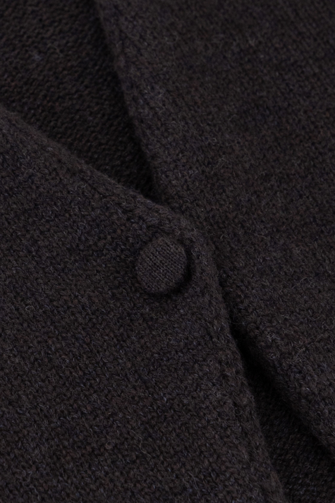 Close up of a dark brown sweater button closure,.