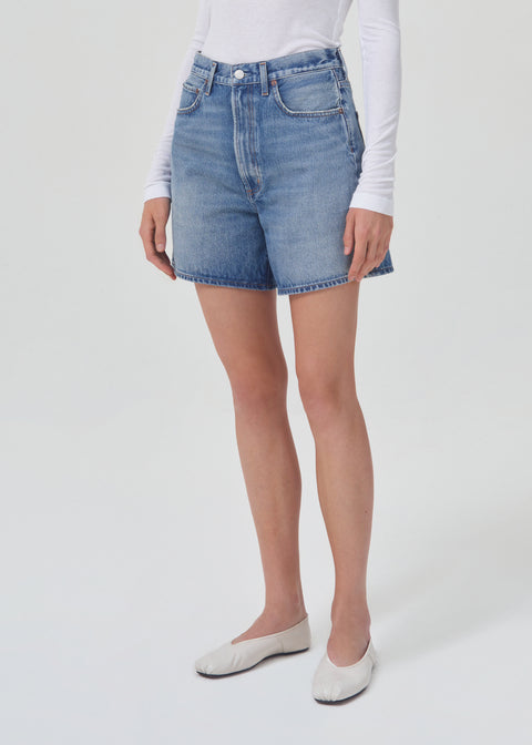 Model turned slightly to the left in the blue denim shorts