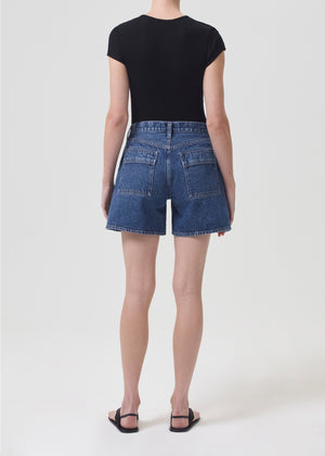 Model facing the back in the blue denim cargo shorts
