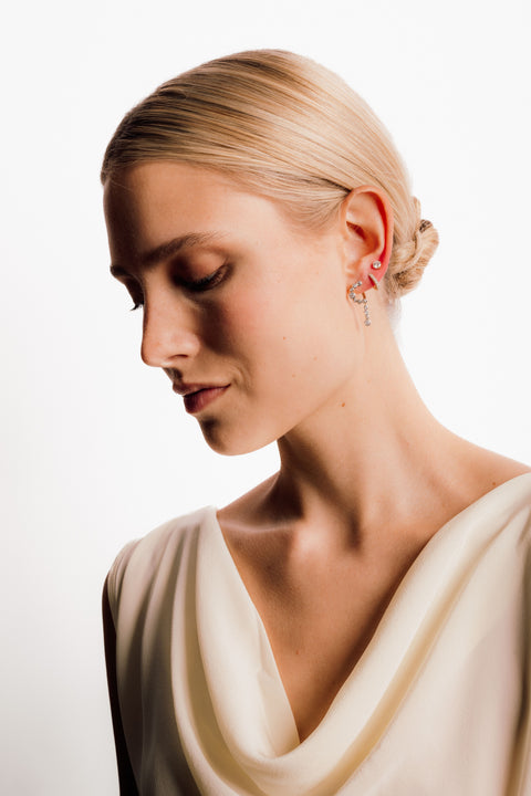 Model wearing three pairs of diamond earrings. 