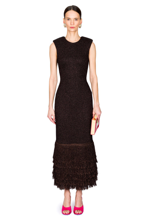 Woman wearing a brown sparkly dress with a textured pattern and ruffled hem on a white background