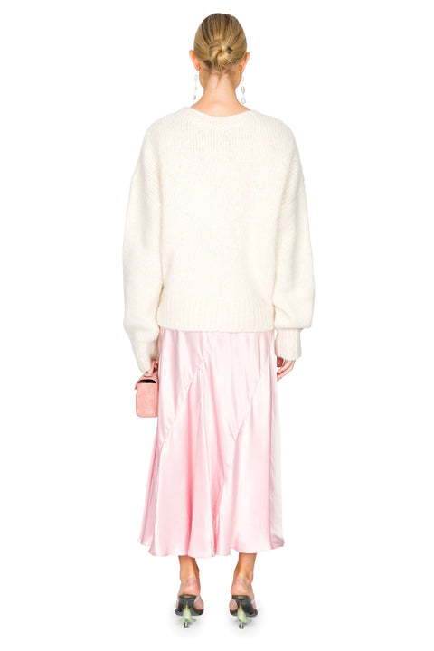Back view of white knit sweater with low hanging ties paired with a pink evening gown