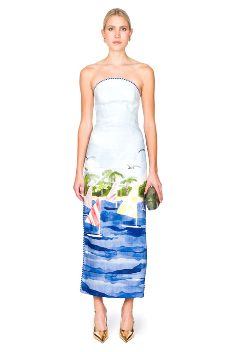 Woman wearing a strapless dress with a sailboat print on a white background
