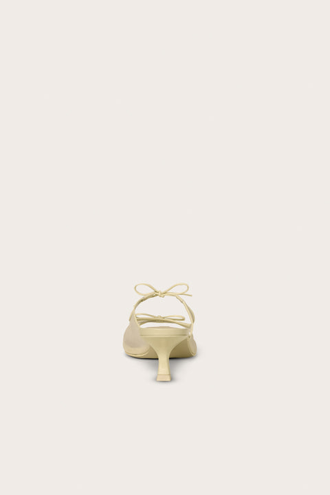 Back view of a cream, open-toe kitten heal that features a mesh side panel design and two bows on the top of the foot. 