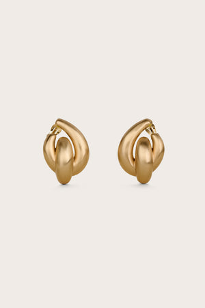 Gold statement earrings that feature a round design with an oblong shape in the middle. 