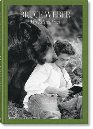 Cover of a coffee table book titled "Bruce Weber: My Education" that features a black and white photo of a man sitting next to a bear with a green border. 