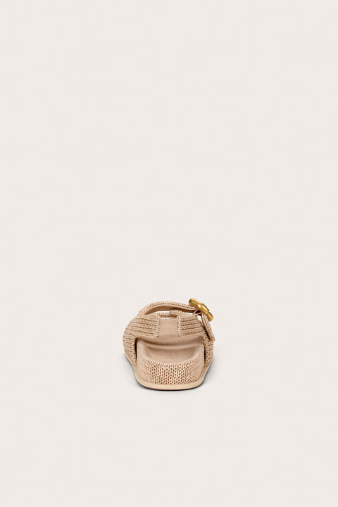 Back view of a raffia sandal that features two straps and a slingback with a gold abstract buckle. 