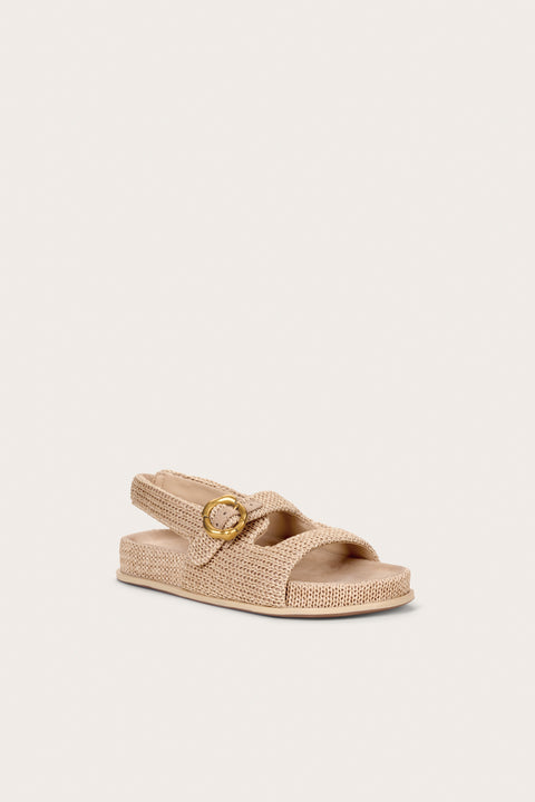 Front view of a raffia sandal that features two top straps and a heel strap with a gold abstract buckle. 