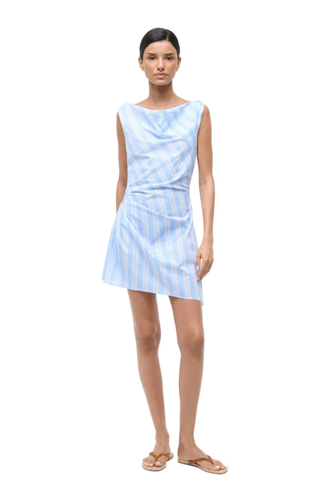 Woman wearing a light blue mini dress with white stripes on a white background