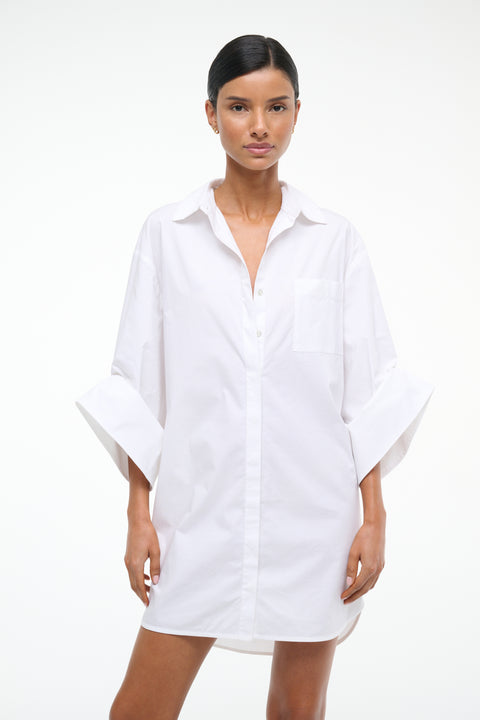 Woman wearing a white oversized shirt dress on a white background