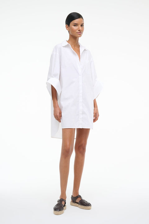 Woman wearing a white shirt dress on a white background