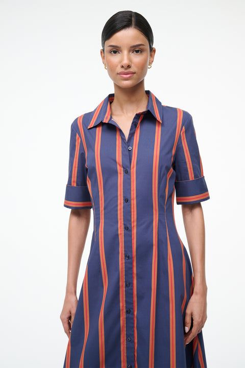 Woman wearing a blue and orange striped dress on a white background